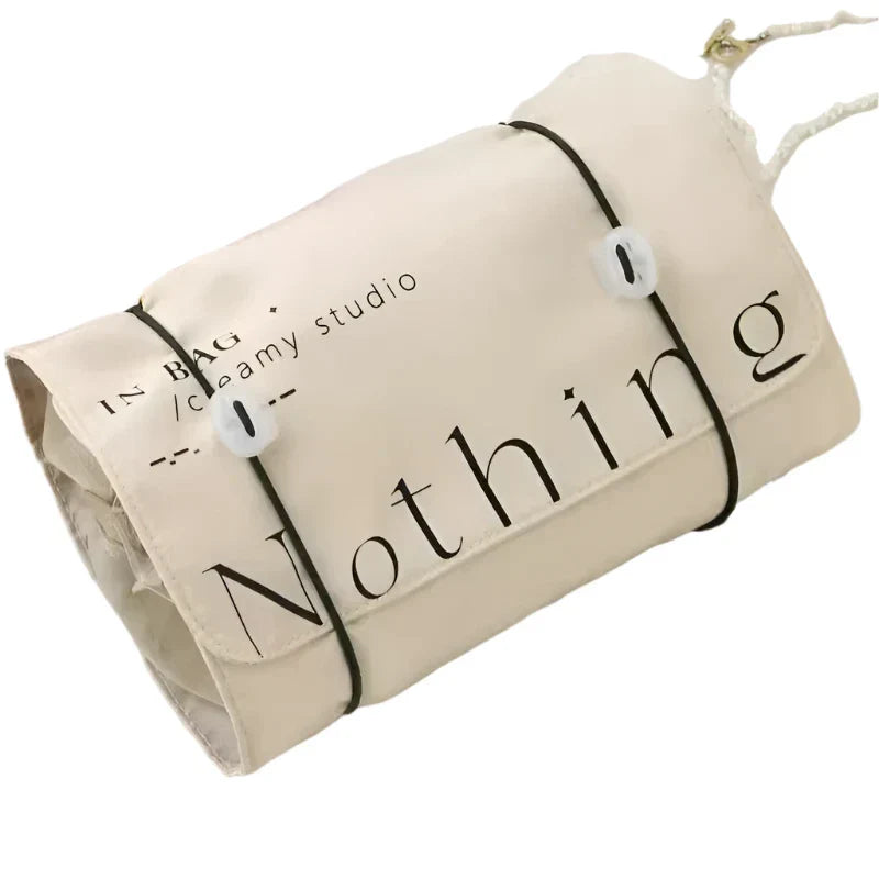 Sacca in tela beige con scritta "Nothing", chiusura a corda, design minimalista. Ideale per shopping, viaggi, moda sostenibile.