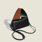 Borsa a tracolla in pelle nera e marrone, design moderno, cinturino regolabile, accessorio moda elegante per donna.