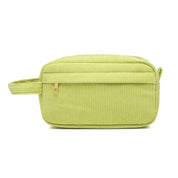 Borsa da toilette verde in velluto a coste con cerniera, manico laterale e design rettangolare. Accessorio da viaggio elegante e pratico.