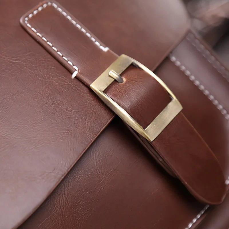 Borsa in pelle marrone con fibbia dorata, cuciture bianche. Accessorio moda elegante, ideale per uomo e donna. Qualità artigianale.