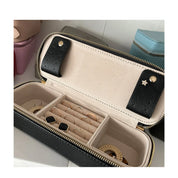 Custodia portagioie in pelle nera aperta con scomparti per anelli, orecchini e bracciali. Design elegante, ideale per viaggi e organizzazione gioielli.