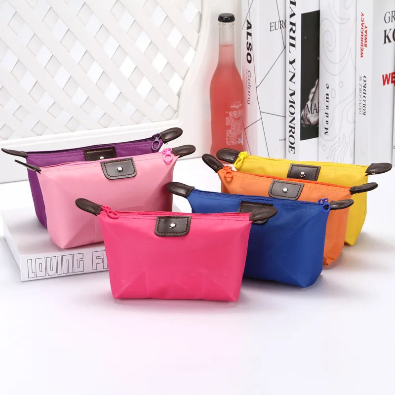 Set di pochette colorate in tessuto impermeabile con cerniera, ideali per cosmetici e accessori. Disponibili in rosa, viola, arancione, blu e giallo.