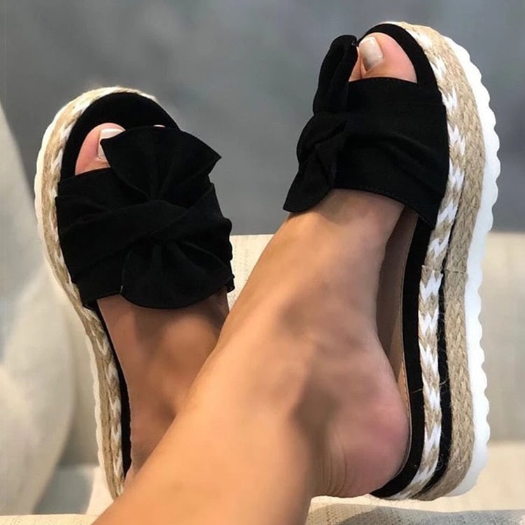 Sandali donna con zeppa in corda, fiocco nero, suola bianca ondulata. Scarpe estive eleganti, comode, perfette per look casual e chic.