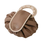 Borsa a mano marrone con manico beige, design moderno e pieghe morbide. Accessorio moda elegante, perfetto per ogni occasione.