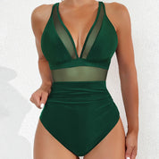 Costume intero verde scuro da donna con inserti in rete trasparente, design elegante e moderno, perfetto per la spiaggia o la piscina.