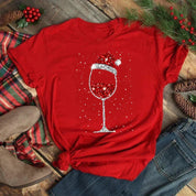 Maglietta rossa natalizia con calice di vino scintillante, decorata con cappello di Babbo Natale. Perfetta per feste e regali di Natale.