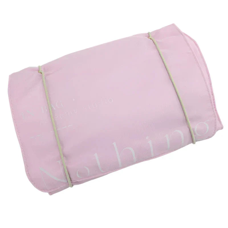 Sacca organizer da viaggio rosa pieghevole, leggera e compatta, ideale per cosmetici e accessori. Design pratico con chiusura a cordoncino.