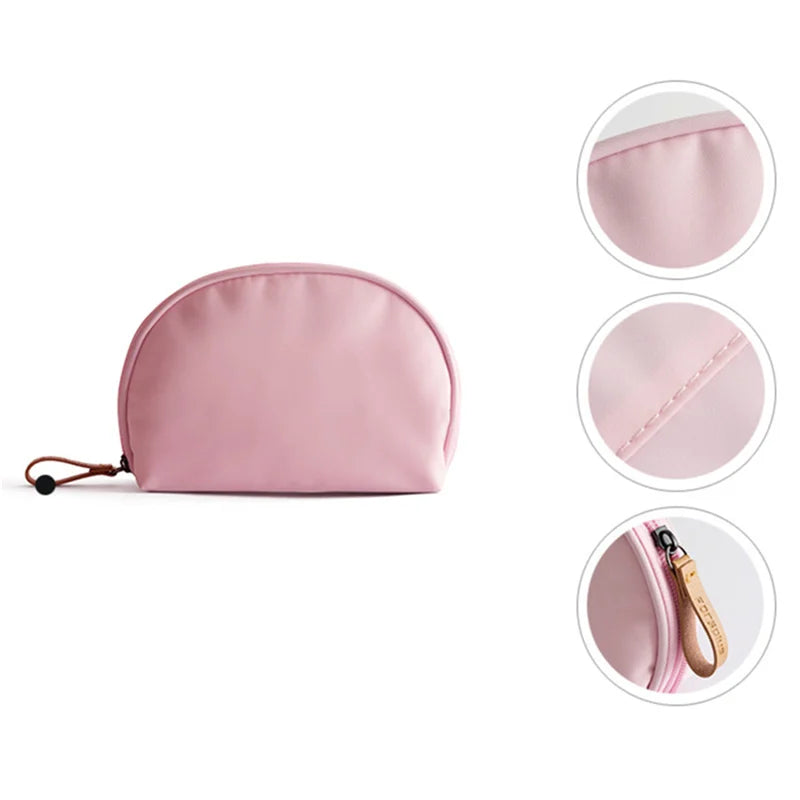 Astuccio cosmetico rosa in tessuto impermeabile, chiusura a zip, dettagli in pelle, ideale per trucco e accessori da viaggio.
