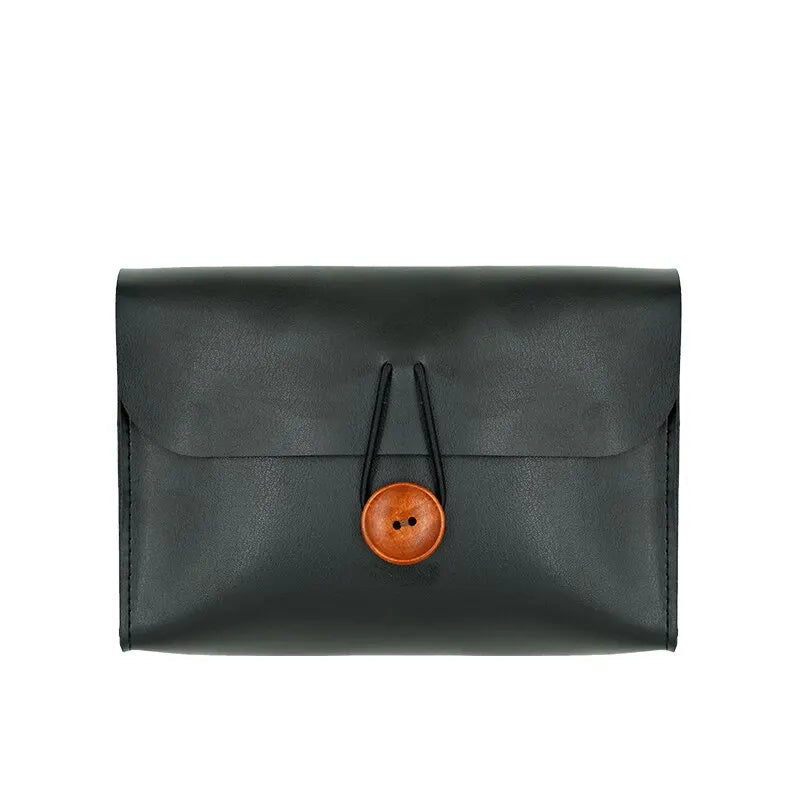 Elegante portafoglio in pelle nera con chiusura a bottone in legno, design minimalista, accessorio moda uomo e donna, alta qualità artigianale.