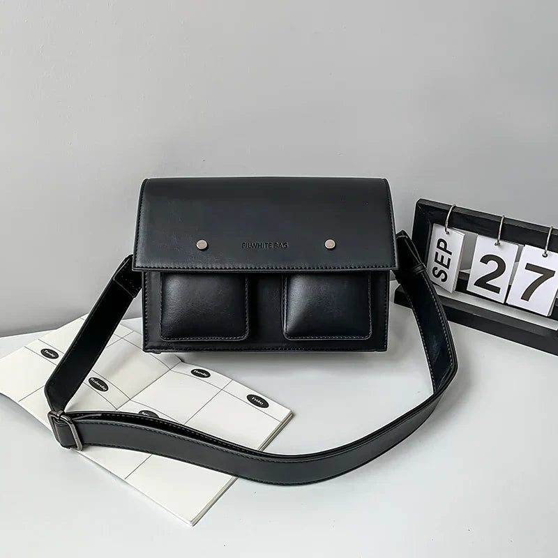 Borsa a tracolla nera in pelle con doppia tasca frontale, design elegante e moderno, ideale per l'uso quotidiano. Data: 27 settembre.