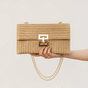 Borsa a tracolla in paglia beige con chiusura dorata e catena, stile estivo elegante, perfetta per moda donna e accessori casual chic.