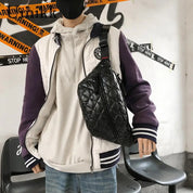 Giacca varsity bianca e viola, felpa con cappuccio bianca, borsa a tracolla nera trapuntata, moda streetwear uomo, stile casual urbano.