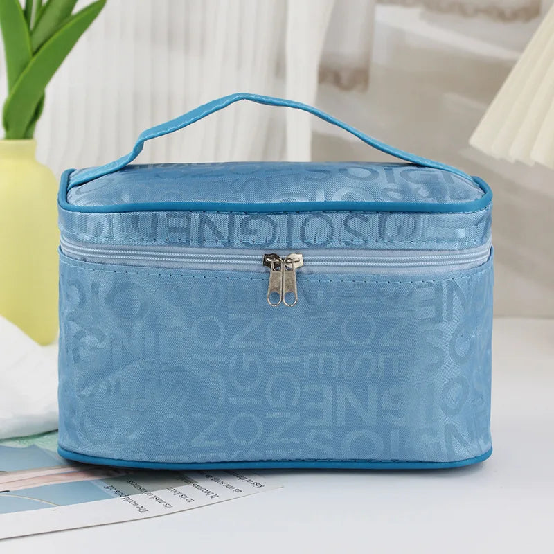 Borsa termica azzurra con manico, chiusura a zip, design con lettere. Ideale per picnic, pranzo al sacco, conservazione cibi. Accessorio pratico e leggero.