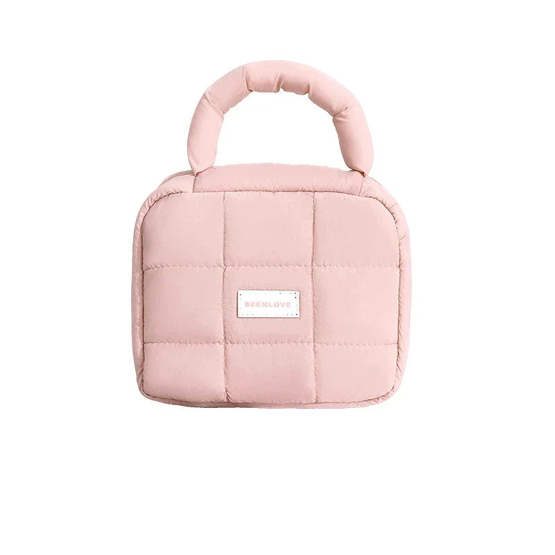 Borsa termica rosa trapuntata con manico imbottito, ideale per pranzo al sacco. Design compatto, perfetta per scuola o ufficio.
