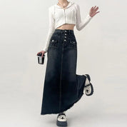 Gonna lunga in denim nero con bottoni, tasche frontali, abbinata a top bianco a coste. Moda casual donna, stile urbano, scarpe platform.