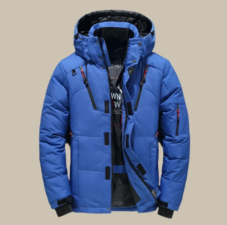 Giacca invernale da uomo blu con cappuccio, imbottitura calda, chiusura a zip, tasche multiple, ideale per sport invernali e attività all'aperto.