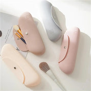 Quattro astucci porta pennelli in silicone color pastello con chiusura a bottone, ideali per organizzare pennelli trucco. Design elegante e funzionale.