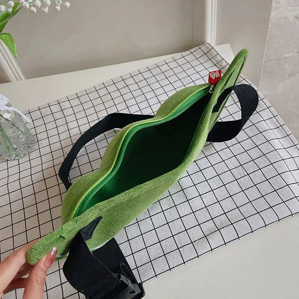 Marsupio verde in tessuto su tovaglia a quadri, con cerniera aperta e cinturino nero regolabile. Accessorio moda casual e pratico.
