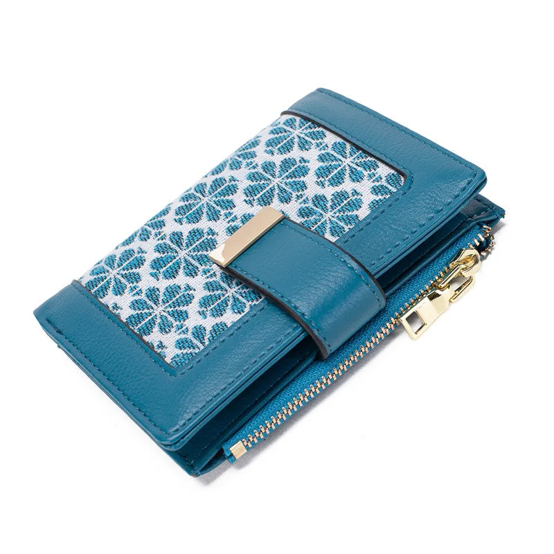 Portafoglio donna in pelle blu con motivo floreale, chiusura a zip dorata e scomparti multipli. Accessorio moda elegante e funzionale.