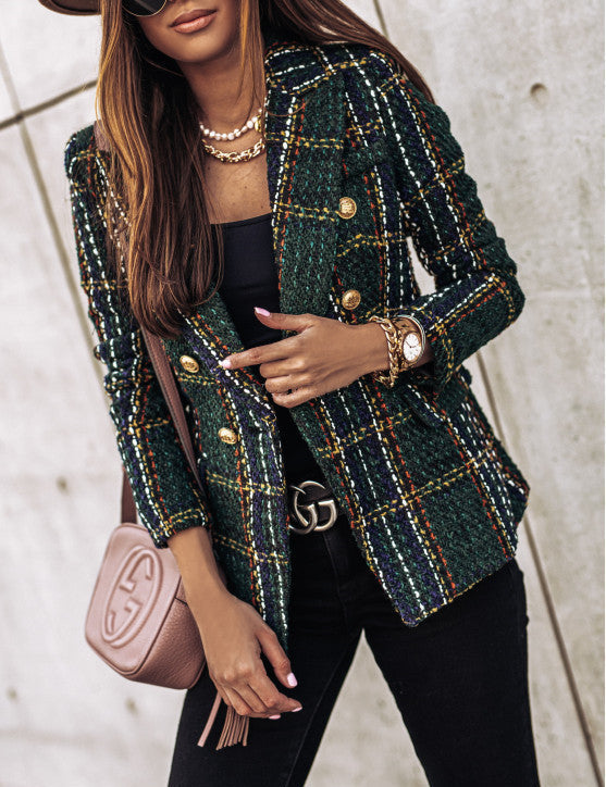 Donna con giacca a quadri verde, bottoni dorati, borsa a tracolla rosa e accessori eleganti. Moda autunnale, stile chic, outfit casual.