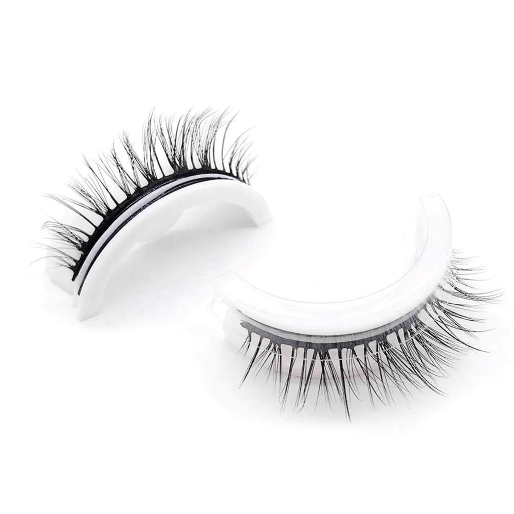 Ciglia finte nere su supporto bianco, effetto voluminoso e naturale, ideali per trucco occhi glamour. Accessorio bellezza di alta qualità.
