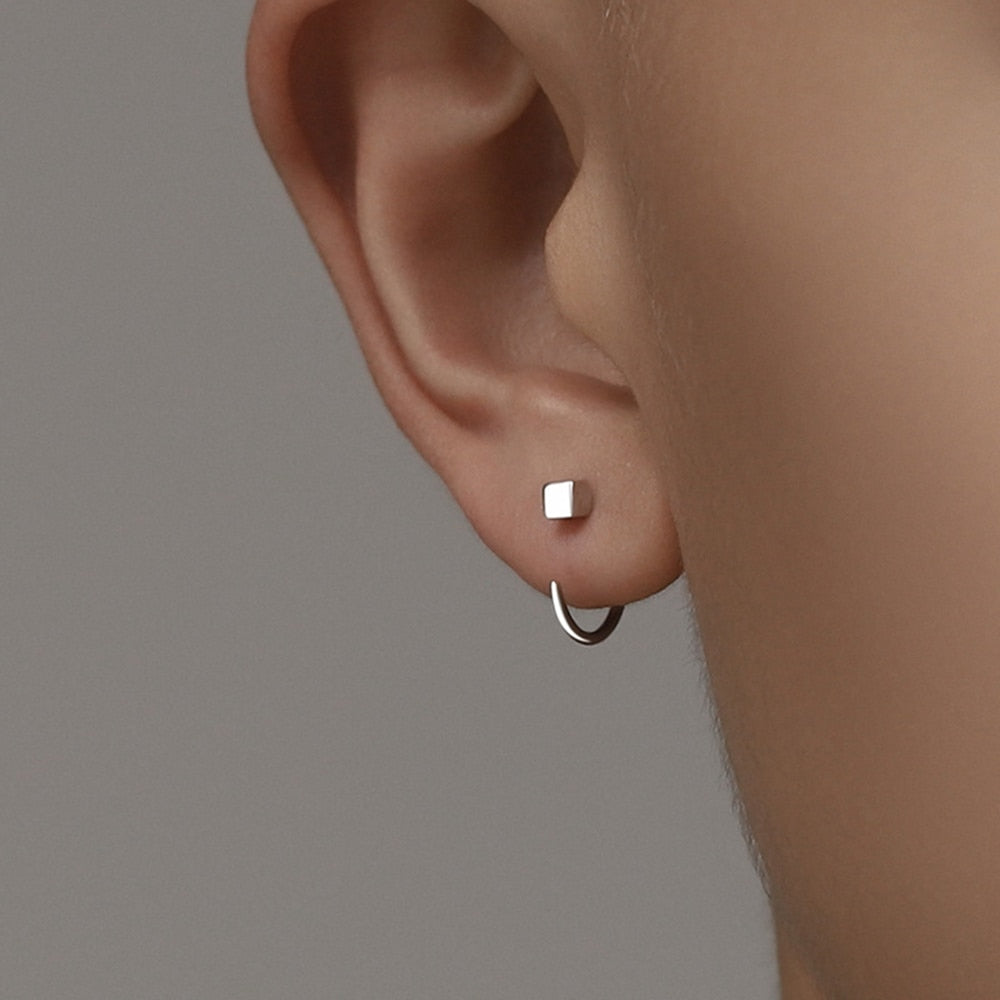 Orecchino a cerchio minimalista in argento su lobo, design moderno, gioielli eleganti, accessori moda, stile contemporaneo, dettaglio orecchio.