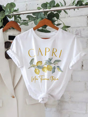 Maglietta bianca con stampa "Capri" e limoni, appesa su gruccia. Design estivo, moda casual, abbigliamento donna, ispirazione italiana.
