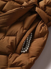 Giacca trapuntata marrone con tasca contenente collana di perle. Moda autunno inverno, abbigliamento donna elegante e caldo.