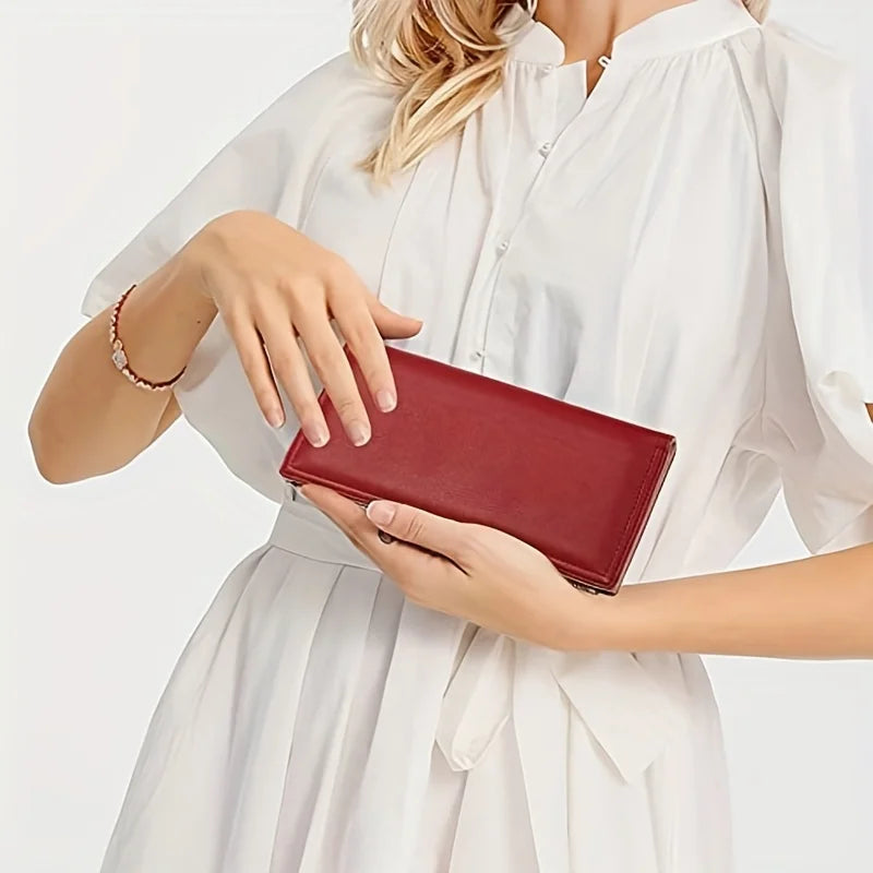 Donna con portafoglio rosso in pelle, elegante e raffinato, indossa abito bianco. Accessorio moda femminile, ideale per look sofisticati.