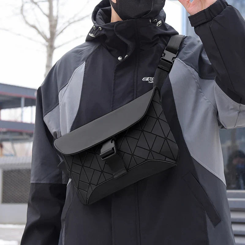 Borsa a tracolla nera con design geometrico indossata su giacca sportiva. Accessorio moda uomo, stile urbano, ideale per viaggi e uso quotidiano.