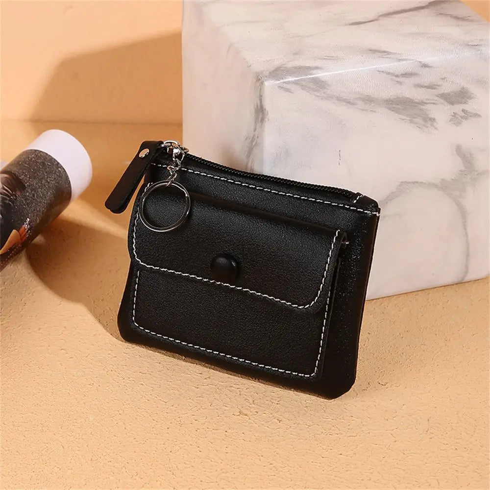 Portamonete in pelle nera con cerniera e anello portachiavi, design elegante, cuciture bianche, ideale per uomo e donna, accessorio moda.