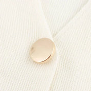 Cardigan bianco in lana con bottone dorato, dettaglio elegante e minimalista. Maglione donna, moda autunno inverno, abbigliamento casual chic.