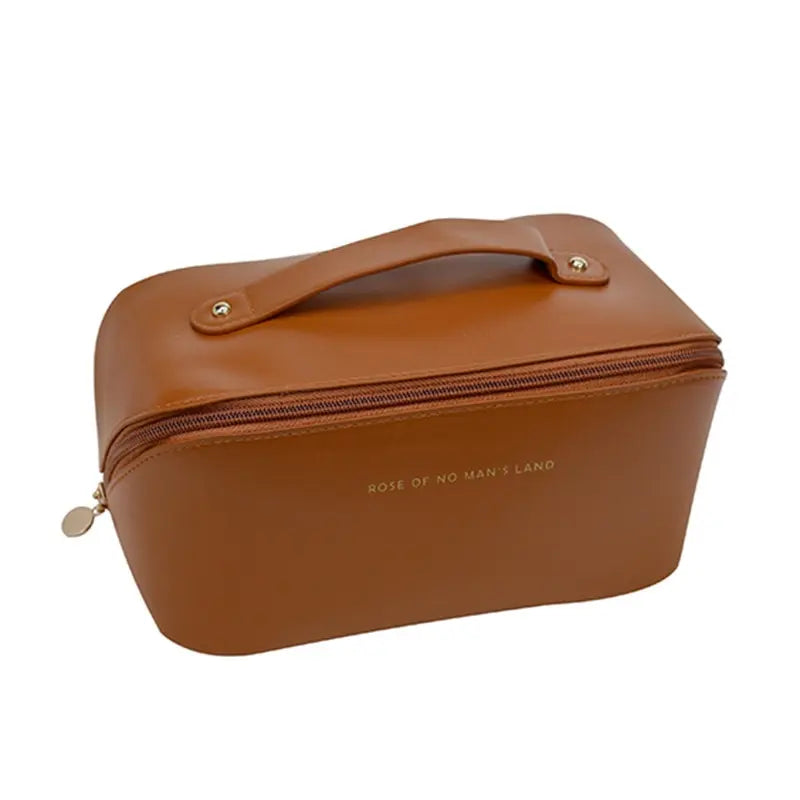 Borsa da toilette in pelle marrone con cerniera e manico, design elegante e compatto, ideale per viaggi. Scritta "Rose of No Man's Land" sul lato.