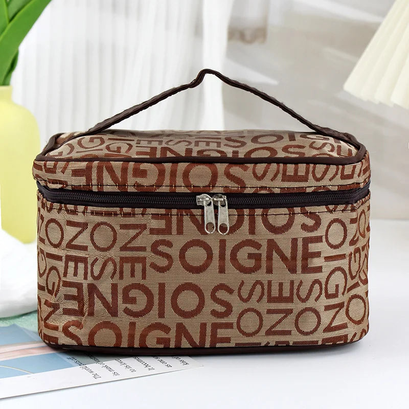 Borsa cosmetica marrone con stampa lettere, chiusura a zip e manico superiore. Ideale per organizzare trucchi e accessori da viaggio.