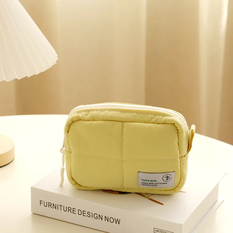 Borsa a tracolla gialla imbottita su tavolo, design moderno, ideale per moda femminile. Accessorio elegante, perfetto per ogni occasione.