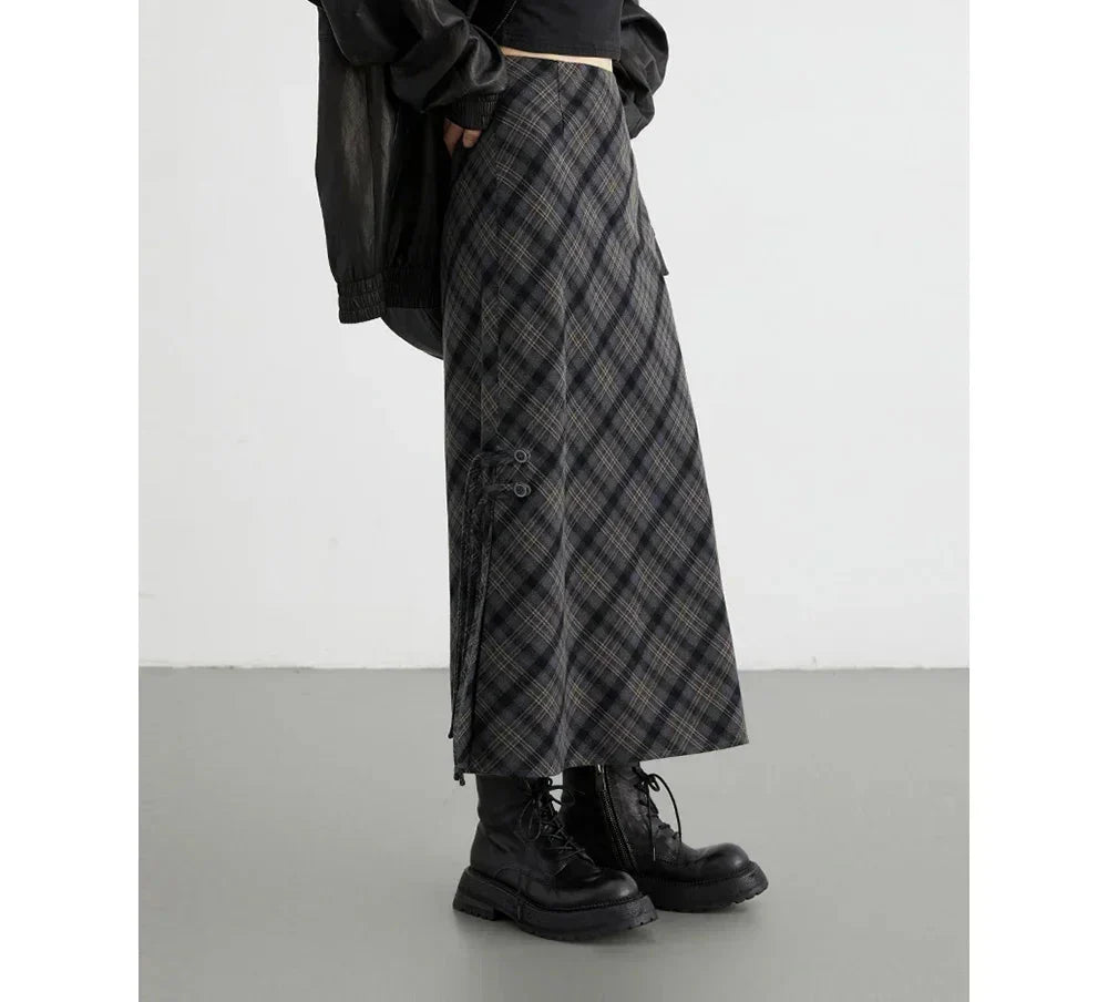 Gonna lunga a quadri grigi e neri, stile casual, abbinata a stivali neri robusti. Moda autunnale, abbigliamento donna, tendenze streetwear.