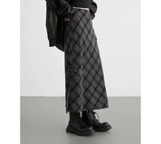 Gonna lunga a quadri grigi e neri, stile casual, abbinata a stivali neri robusti. Moda autunnale, abbigliamento donna, tendenze streetwear.