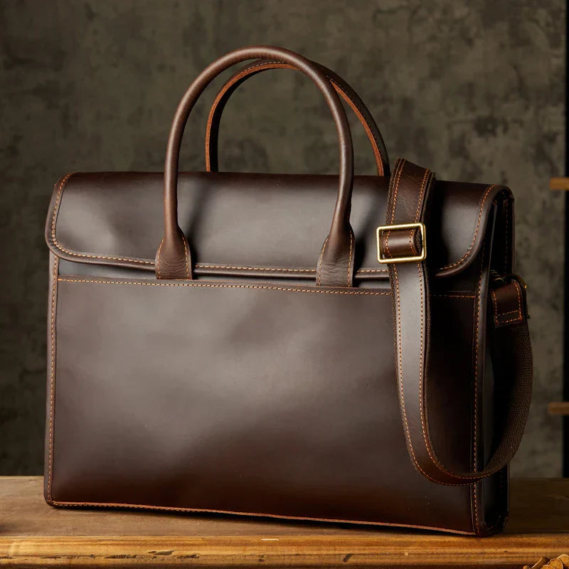 Borsa ventiquattrore in pelle marrone scuro con manici e tracolla regolabile, design elegante e professionale, ideale per lavoro e ufficio.