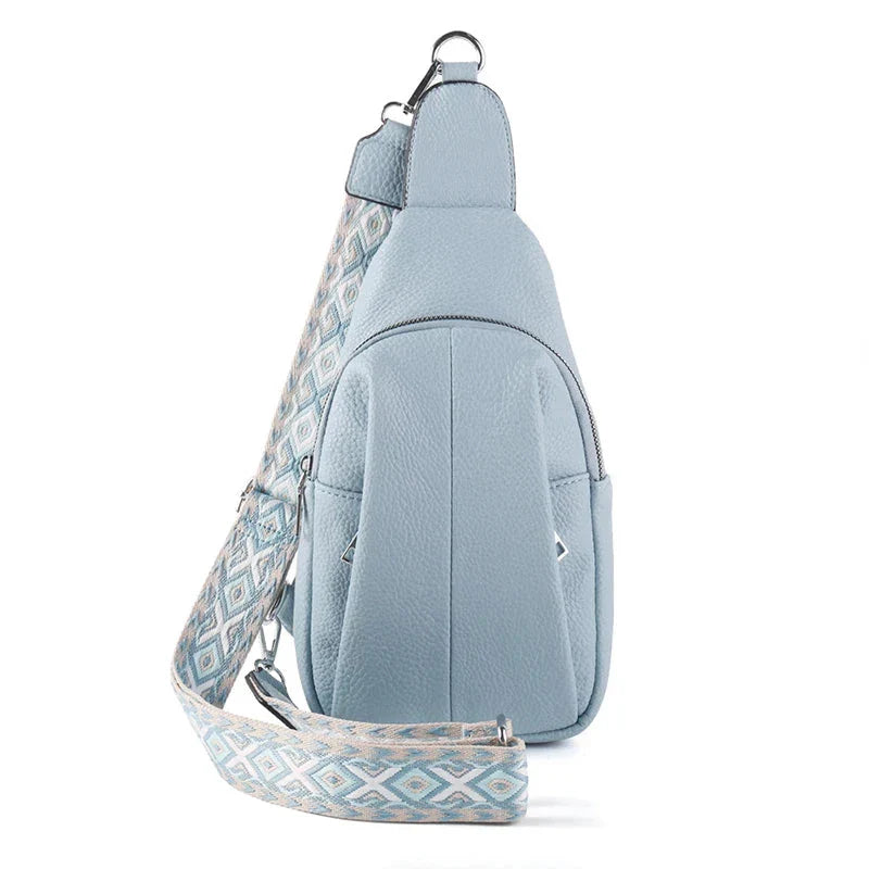Zaino monospalla in pelle azzurra con tracolla regolabile a motivo geometrico, tasca frontale con zip. Accessorio moda donna elegante e pratico.