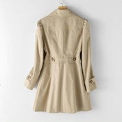 Cappotto trench beige da donna, lungo, con cintura e bottoni, stile classico, ideale per autunno e primavera. Elegante e versatile.