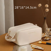 Borsa cosmetica beige in pelle PU, dimensioni 28x16x14.5 cm, con cerniera, ideale per trucco e accessori da viaggio. Elegante e spaziosa.