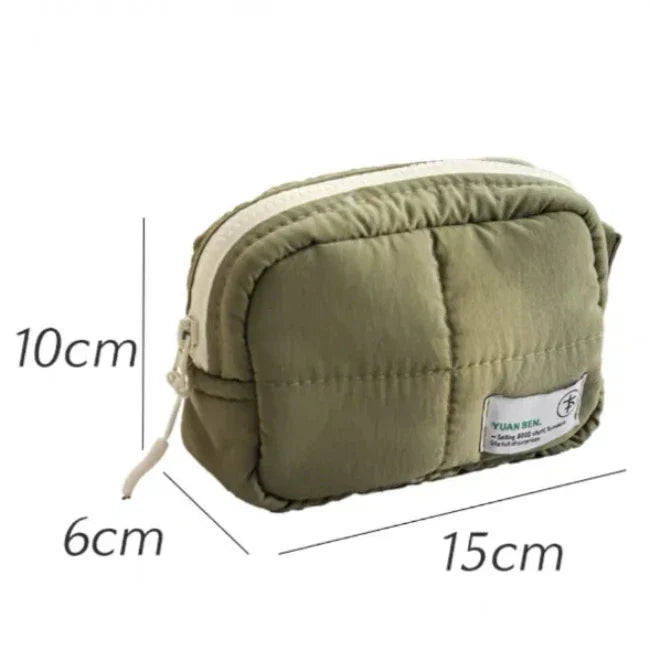 Borsetta verde trapuntata con cerniera, dimensioni 15x10x6 cm, ideale per cosmetici o accessori. Design compatto e pratico per viaggi.
