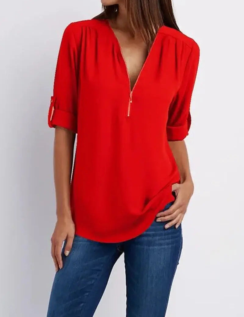 Donna con camicia rossa a maniche lunghe con zip, abbinata a jeans blu. Moda casual femminile, abbigliamento trendy, stile autunnale.
