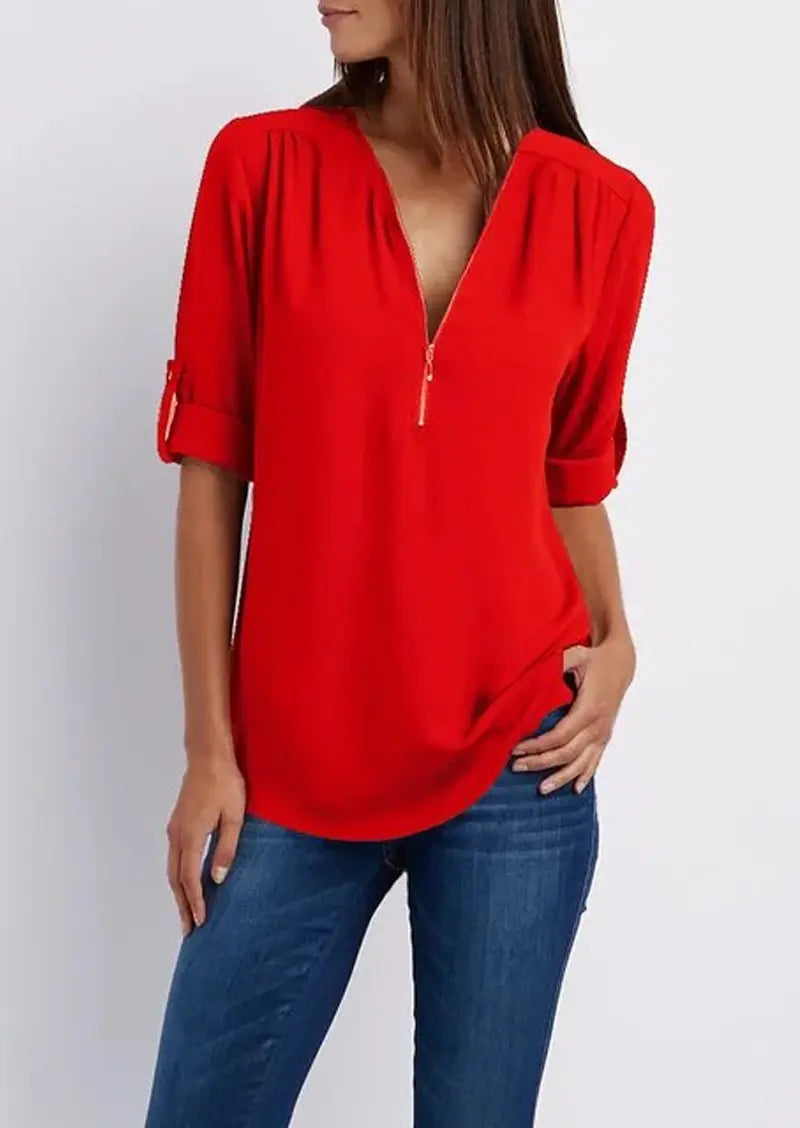 Donna con camicia rossa a maniche lunghe con zip, abbinata a jeans blu. Moda casual femminile, abbigliamento trendy, stile autunnale.