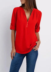 Donna con camicia rossa a maniche lunghe con zip, abbinata a jeans blu. Moda casual femminile, abbigliamento trendy, stile autunnale.