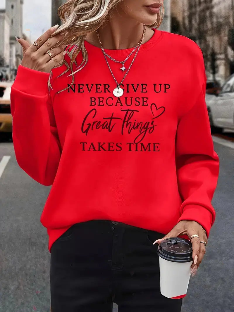 Donna con felpa rossa con scritta motivazionale, collane a strati, anelli, e caffè da asporto. Moda casual, abbigliamento autunnale, street style.