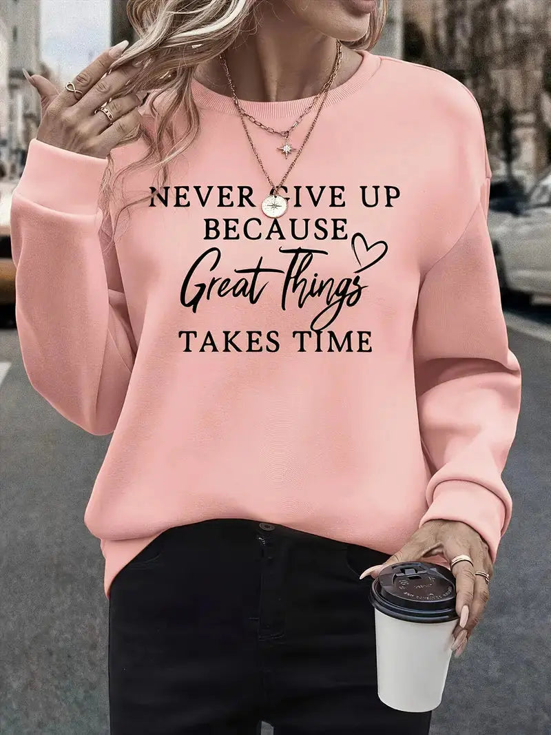 Donna con felpa rosa con scritta motivazionale, collane dorate, e caffè da asporto. Moda casual autunnale, abbigliamento streetwear femminile.