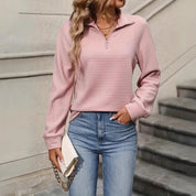 Donna con maglione rosa a coste, jeans blu e borsa bianca a catena. Moda casual autunnale, abbigliamento femminile trendy.