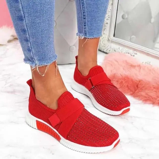 Scarpe da ginnastica rosse da donna con strass, suola bianca, indossate con jeans. Sneakers eleganti e comode per moda casual.