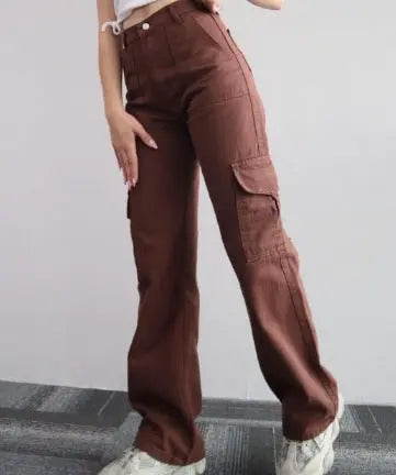 Pantaloni cargo marroni da donna, a vita alta, con tasche laterali, indossati con scarpe bianche. Stile casual e moderno.